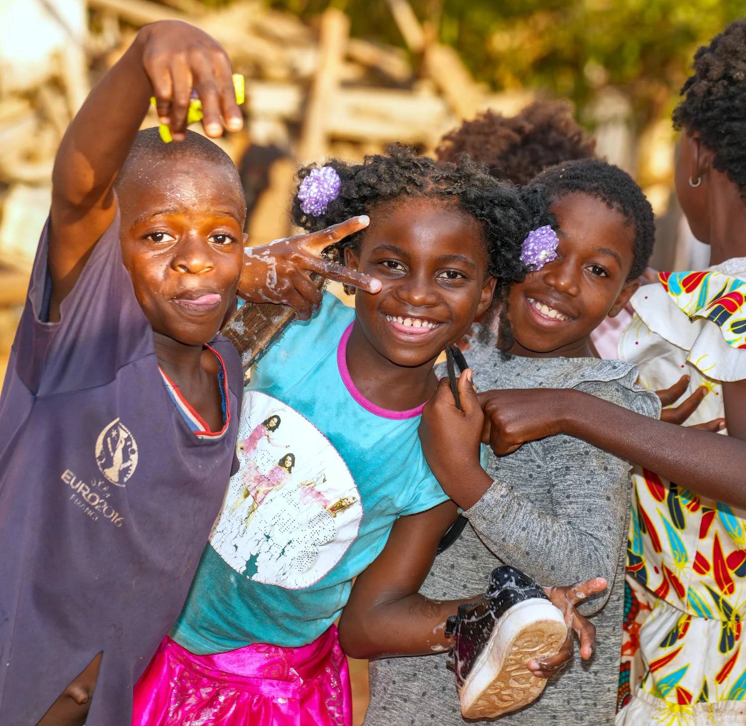 Kids from RJYSF's programs smiling and waving at the camera